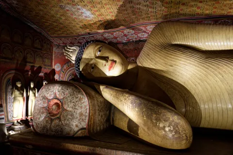 The reclining Buddha beneath painted ceilings in Dambulla's caves