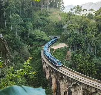 The blue train crossing the Nine Arch Bridge near Ella