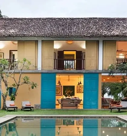A colonial-style boutique villa with a pool and blue shutters