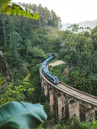 The blue train crossing the Nine Arch Bridge near Ella