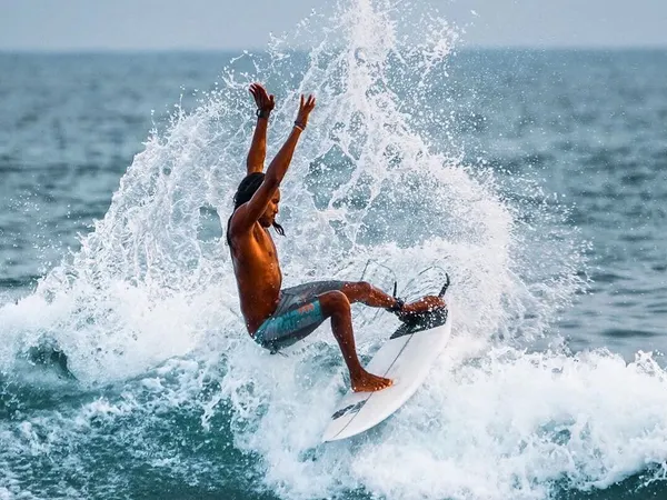 A surfer throwing spray off the top of a wave